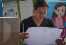 Una funcionaria electoral revisa las listas de votantes mientras se reanuda la votación en los colegios electorales afectados por retrasos y problemas logísticos durante las elecciones generales en Lima, Perú, el lunes 13 de abril de 2026. (AP Foto/Guadalupe Pardo)